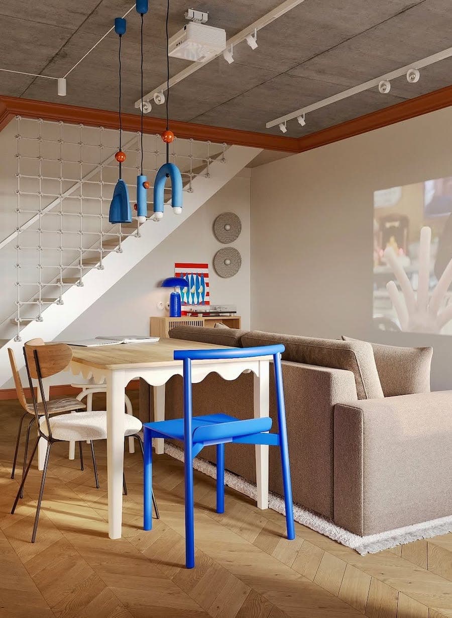 Departamento tipo loft moderno decorado con estilo disruptivo. Los muebles, paredes y decoración en general es de color beige y crema, pero hay una silla y lámpara de color azul eléctrico que destaca.